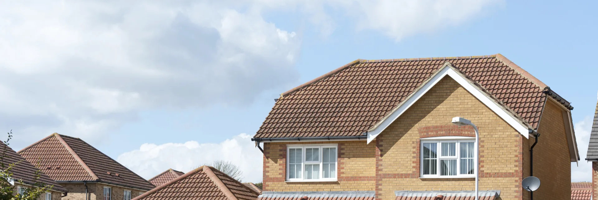 Detached brick house with a hipped roof of red tiles