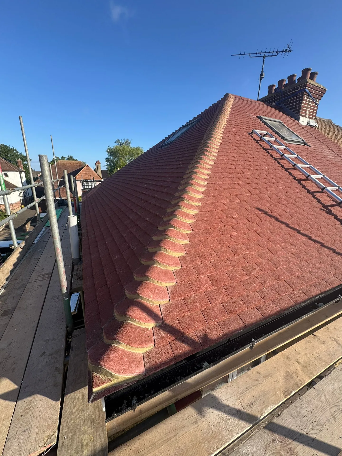 Red tiled roof with a lead-flashed chimney, seen from the scaffold